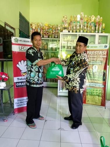 Penyerahan paket sembako BAZNAZ oleh Kepala Madrasah 